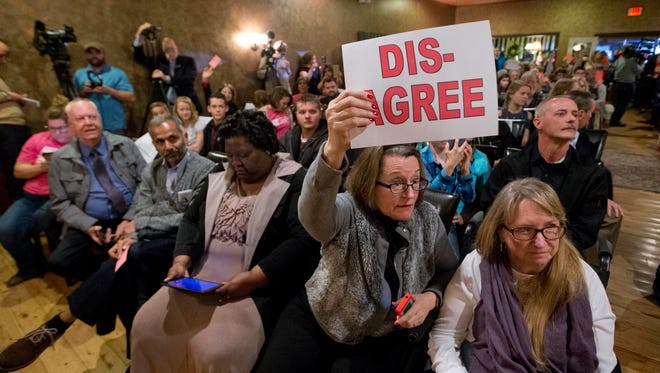 Constituents of Rep. Dave Brat, R-Va., hold signs as he answers questions during a town hall meeting in Blackstone, Va., on Feb. 21, 2017.