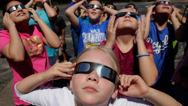People practice using eclipse glasses in Kansas City, Mo.,  on Aug. 18, 2017.