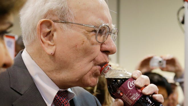 Berkshire Hathaway Chairman and CEO Warren Buffett drinks from a bottle of Cherry Coke prior to the annual shareholders meeting in 2014, in Omaha, Neb. During the meeting Buffett told shareholders he had abstained from voting Berkshire's 400 million shares against Coca Cola's compensation plan even though he had long advocated against exorbitant executive pay.
