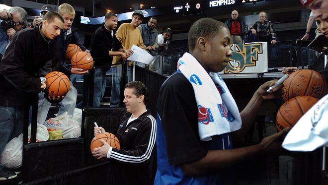 March 22, 2006  - Memphis' head coach John Calipari, left, and Kareem Cooper, right, sign autographs for fans before practice at the Oakland Arena. The Tigers will take on Bradley in their sweet sixteen NCAA tournament game Thursday.