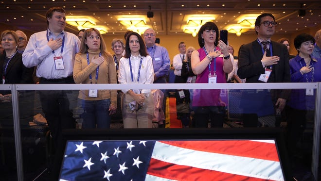 Attendants stand as the Star-Spangled Banner is performed during the first day of the Conservative Political Action Conference.