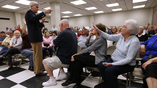 Sen. Bill Cassidy, R-La., responds to a question asked by June Butler, right, during a town hall meeting on Feb. 23, 2017, in Thibodaux, La. Butler asked Cassidy whether he could guarantee that people insured under the Affordable Care Act would still be covered by the senator's new health care plan.