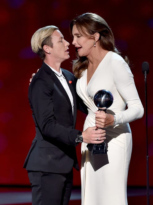Caitlyn Jenner accepts the Arthur Ashe Courage Award from former professional soccer player Abby Wambach onstage.