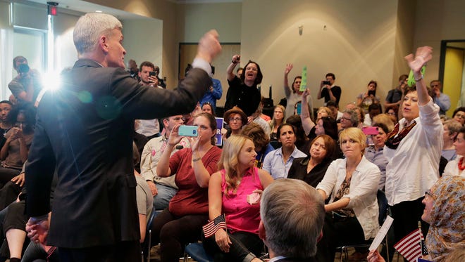Sen. Bill Cassidy, R-La., tries to pick a member among a crowd to listen to a question during his town hall meeting at East Jefferson Regional Library in Metairie, La., on Feb. 22, 2017.