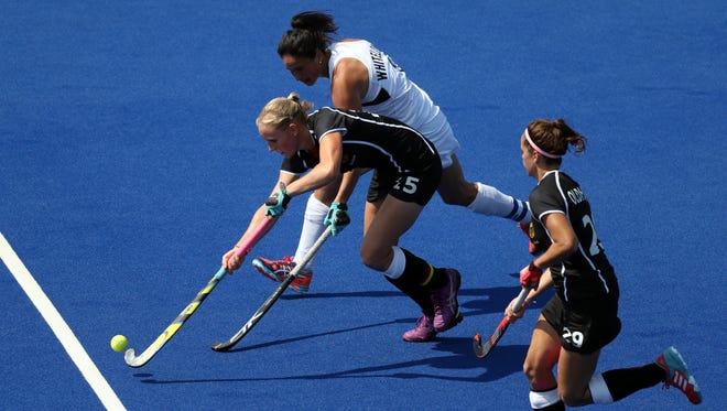 Germany and New Zealand fight for a loose ball during the bronze match in the Rio 2016 Summer Olympic Games at Olympic Hockey Centre.