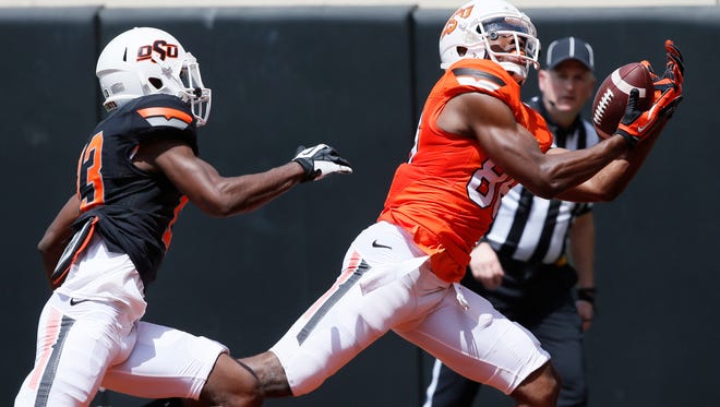 Oklahoma State wide receiver Obi Obialo catches a pass in front of cornerback Lamarcus Morton during the team's spring game.