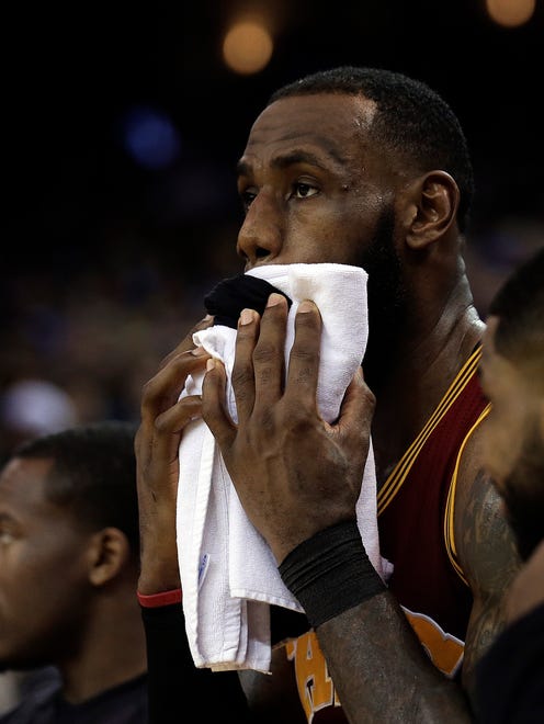 Cleveland Cavaliers' LeBron James wipes his face during the second half.