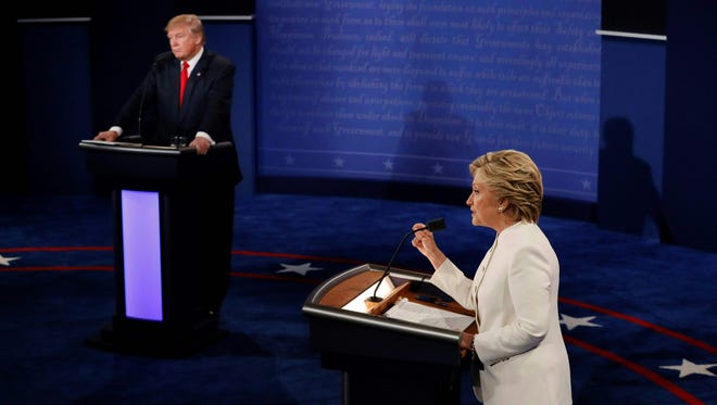 Clinton speaks as Trump looks on during their final presidential debate in Las Vegas on Oct. 19, 2016.