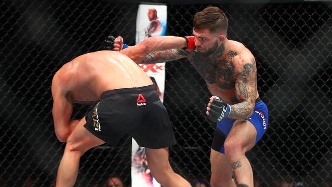 Cody Garbrandt moves in with a punch against Dominick Cruz.
