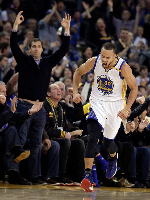 Golden State Warriors' Stephen Curry celebrates a score against the Cleveland Cavaliers.
