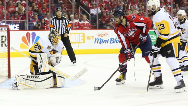 Pittsburgh Penguins goalie Marc-Andre Fleury makes a save in front of the Washington Capitals' Alex Ovechkin.