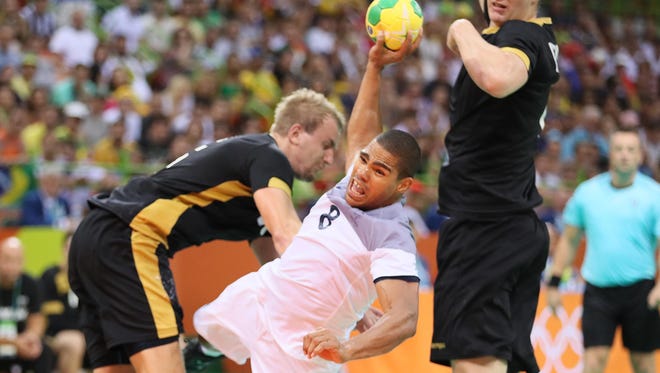 France center back Daniel Narcisse shoots the ball in a men's semifinal handball match against Germany.