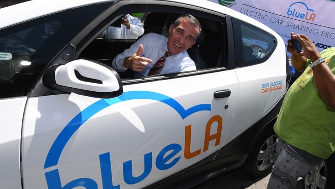 Los Angeles Mayor Eric Garcetti tries out a car at the launch of what is being billed as the nation's largest electric vehicle' car sharing program for disadvantaged communities