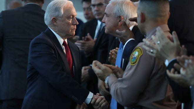 Attorney General Jeff Sessions shakes hands with Miami-Dade Mayor Carlos Gimenez.
