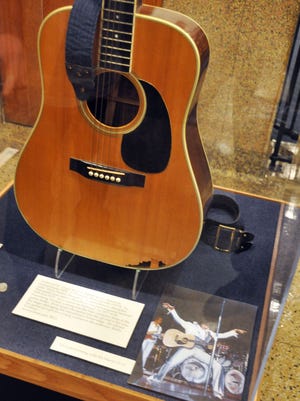FILE - This April 22, 2013 file photo shows the slightly smashed acoustic guitar played by Elvis Presley during the final tour before his death in 1977 on display at the National Music Museum in Vermillion, S.D. The guitar may have to taken off display. A lawsuit filed in July 2014 in South Dakota is seeking to determine who is the legal owner of the guitar. Memphis-based guitarist Robert Johnson donated the Elvis guitar last year to the museum, but a man now claims he is the owner of the slightly smashed acoustic guitar. (AP Photo/Dirk Lammers, File)