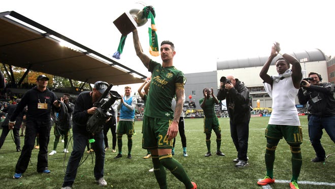 Portland Timbers defender Liam Ridgewell (24) raises the Cascadia Cup after Timbers defeated the Vancouver Whitecaps 2-1 at Providence Park.