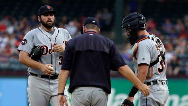 Tigers pitcher Michael Fulmer, left, talks with pitching coach Rich Dubee, center, and catcher James McCann, right, during a mound visit in the first inning on Monday, Aug. 14, 2017, in Arlington, Texas.