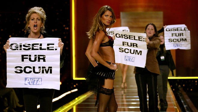 Supermodel Gisele Bundchen struts on the runway during the 2002 Victoria's Secret fashion show at New York City's Lexington Avenue Armory, even as PETA activists take the stage.