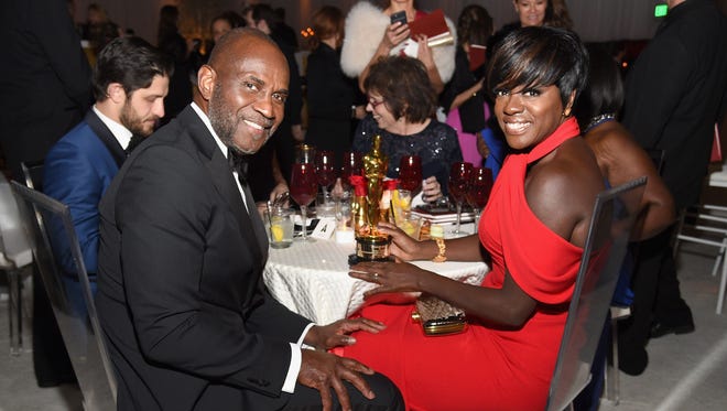 Viola Davis and her husband Julius Tennon grab a seat at the Governors Ball after the Oscars.