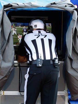 NFL referee Terry McAulay (77) assess a replay during a 2014 game.