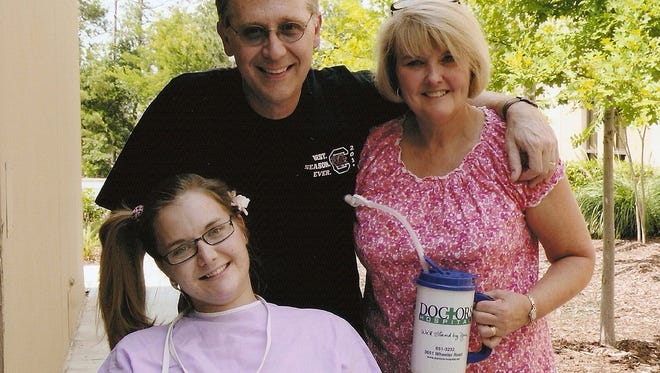 In this Saturday, June 23, 2012 file photo provided by the Copeland family, Aimee Copeland, left, poses with her parents, Andy and Donna Copeland, outside Doctors Hospital in Augusta, Ga. Aimee Copeland was released from Doctors Hospital on July 2, 2012.