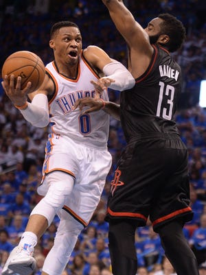 Oklahoma City Thunder guard Russell Westbrook drives to the basket in front of Houston Rockets guard James Harden.