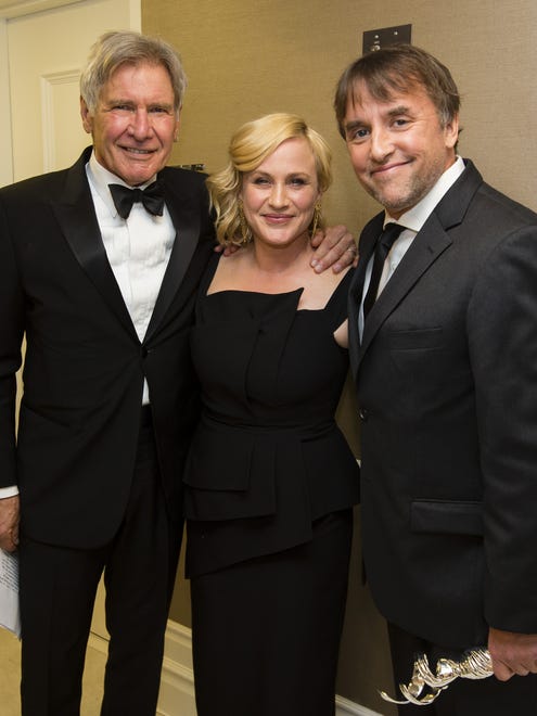 Presenter Harrison Ford, left,  Patricia Arquette and honoree Richard Linklater (holding the Distinguished Collaborator Award) attend the  Costume Designers Guild Awards at The Beverly Hilton Hotel on Feb. 17, 2015.