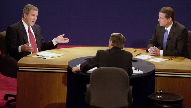 Gore listens Bush answers a question from moderator Jim Lehrer during the Oct. 11, 2000, debate at Wake Forest University in Winston-Salem, N.C.