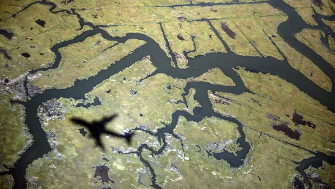 The shadow of Air Force flies over marshland while on approach to New York's John F. Kennedy International Airport Sept 24, 2012.
