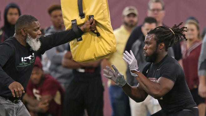 Dalvin Cook, right, works on a drill with an NFL scout during Florida State's pro day, Tuesday, March 28, 2017 in Tallahassee, Fla.
