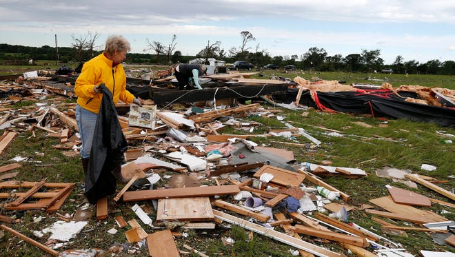Two women retrieve items for their neighbor from the remains of their trailer home that was destroyed when a large tornado hit the area near Canton, Texas on  April 30, 2017.