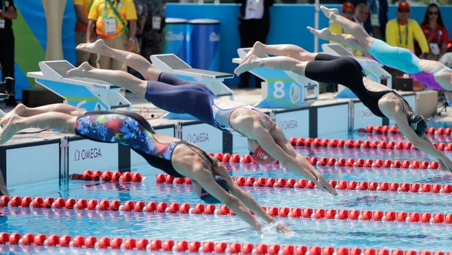 Competitors dive into the pool during the women's individual swimming portion of the modern pentathlon competition in the Rio 2016 Summer Olympic Games at Deodoro Aquatics Centre.