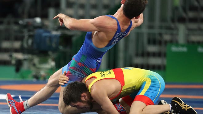 Nurislam Sanayev of Kazakhstan, bottom, tries to take down Haji Aliyev of Azerbaijan during the 57-kg freestyle wrestling competition.
