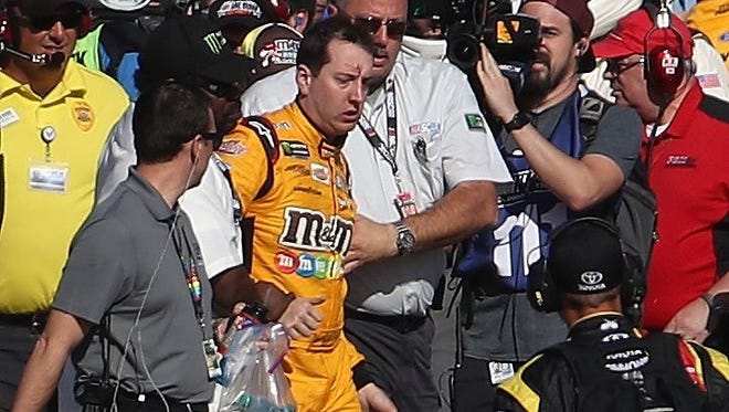 Kyle Busch walks away with a bloody forehead after a scuffle with Joey Logano and his crew on pit road in Las Vegas.