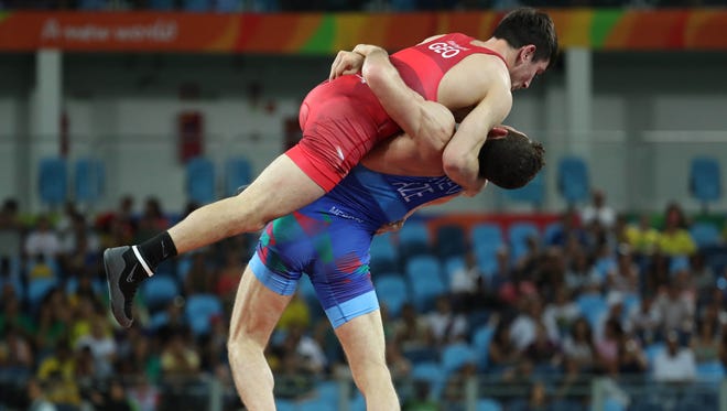 Haji Aliyev of Azerbijan lifts up Vladimer Khinchegashvili of Georgia during men's freestyle wrestling competition in the Rio 2016 Summer Olympic Games at Carioca Arena 2.