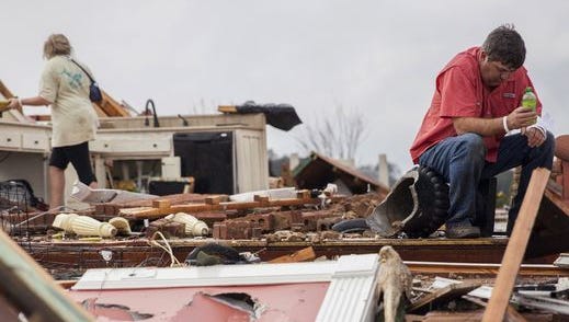 Jeff Bullard sits in what used to be the foyer of his home as his daughter, Jenny Bullard, looks through debris at their home that was damaged by a tornado on Jan. 22, 2017 in Adel, Ga. The severe weather outbreak killed 24 people and caused $1.1 billion in damages.