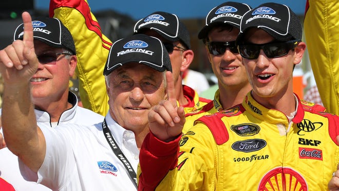 Team owner Roger Penske, left, and driver Joey Logano, right, earned their first win together at Michigan International Speedway in August 2013.