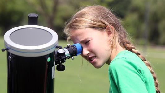 Gillian Hester looks at the sun through a solar telescope during an eclipse party on Aug. 21, 2016, in Nashville.