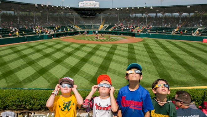 Finnegan Putney, 8, Noah Putney, 9, Spencer McCurry, 9 and Connor McCurry, 7, all from Midlothian, Va., watch the solar eclipse between games at the Little League World Series in South Williamsport, Pa.