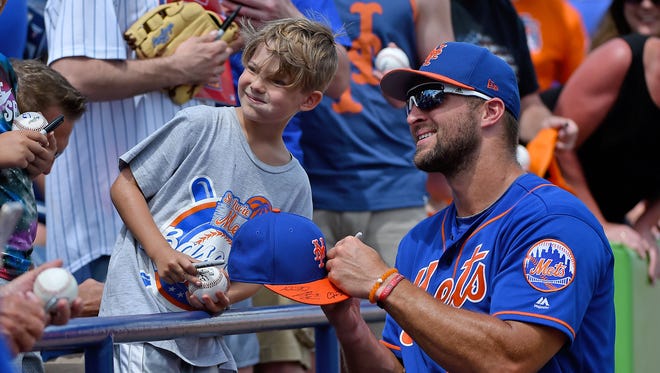 March 27: Tim Tebow signs an autograph for a young fan.