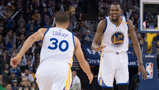 Kevin Durant (35) celebrates with Stephen Curry (30) during the third quarter against the Cleveland Cavaliers.