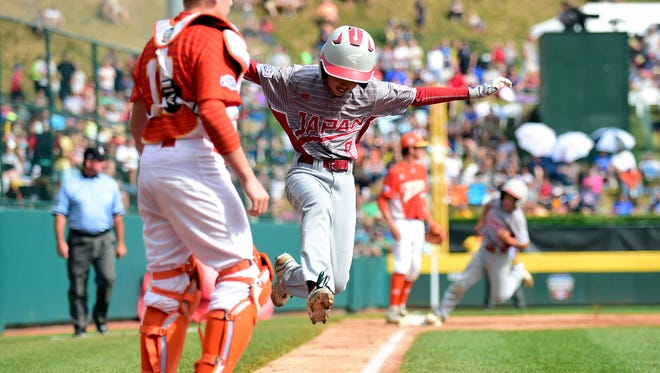 Japan outfielder Kazuki Watanabe (8) scores during the second inning against Texas.