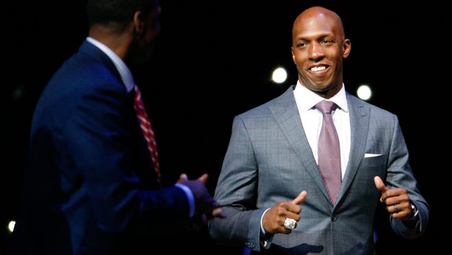 Retired professional basketball player Chauncey Billups smiles at Isiah Thomas as he walks onto the court during halftime in the game between the Detroit Pistons and the Denver Nuggets at The Palace of Auburn Hills.