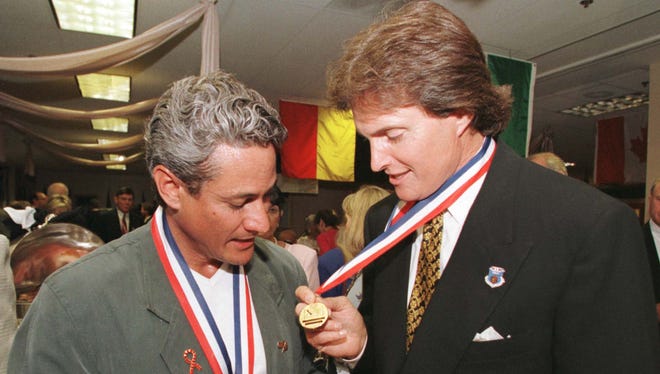 Olympians, Greg Louganis (left ) and Jenner share a moment looking at each others medals in 1996.