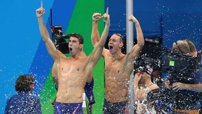Michael Phelps and Caeleb Dressel celebrate after winning the men's 4x100m freestyle relay final.