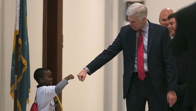 Gorsuch fist-bumps 4-year-old Charles Marshall III of Dover, Del., during a visit to Capitol Hill on Feb. 8, 2017.