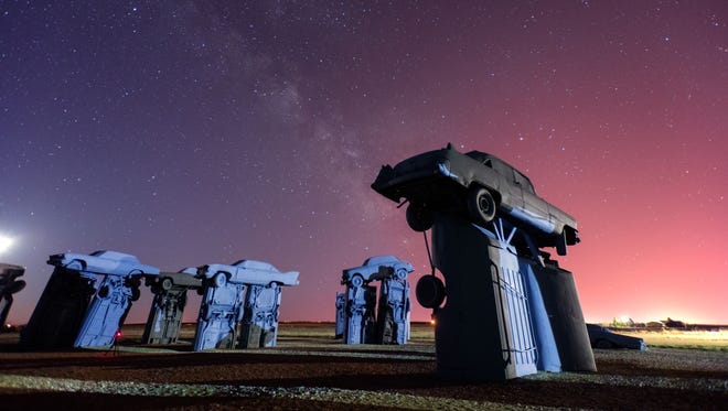 Night falls and the stars come out over Carhenge.