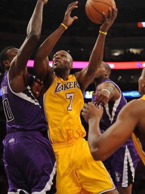 Los Angeles, CA, USA; Los Angeles Lakers forward Lamar Odom (7) goes up for a layup defended by Sacramento Kings center Samuel Dalembert (10) at the Staples Center.