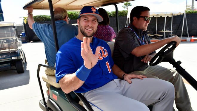 Feb. 27: Tim Tebow leaves on a golf cart after addressing members of the media on his firt day at camp.
