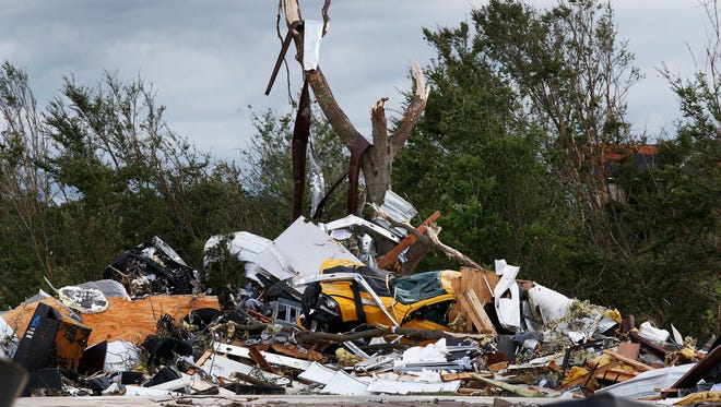 Cars and damaged material is seen piled up at a local car dealership that was destroyed when a large tornado hit the area near Canton, Texas, on April 29, 2017.